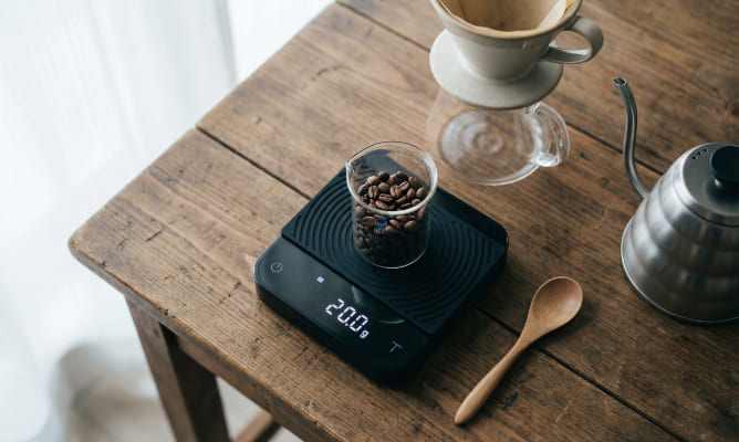 Preparo de café com balança digital e grãos frescos.