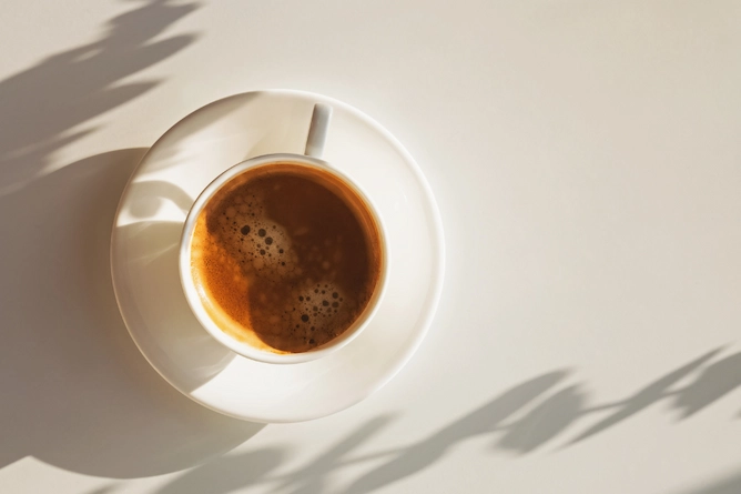 em uma mesa, o sol ilumina uma xícara de café