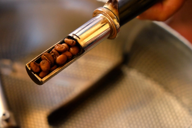 prova de torra, quando a pessoa que está torrando o café vê o ponto da torra dentro da máquina, cilíndrico de metal