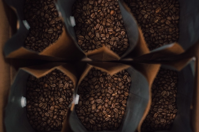 seis pacotes de café em grãos abertos vistos de cima